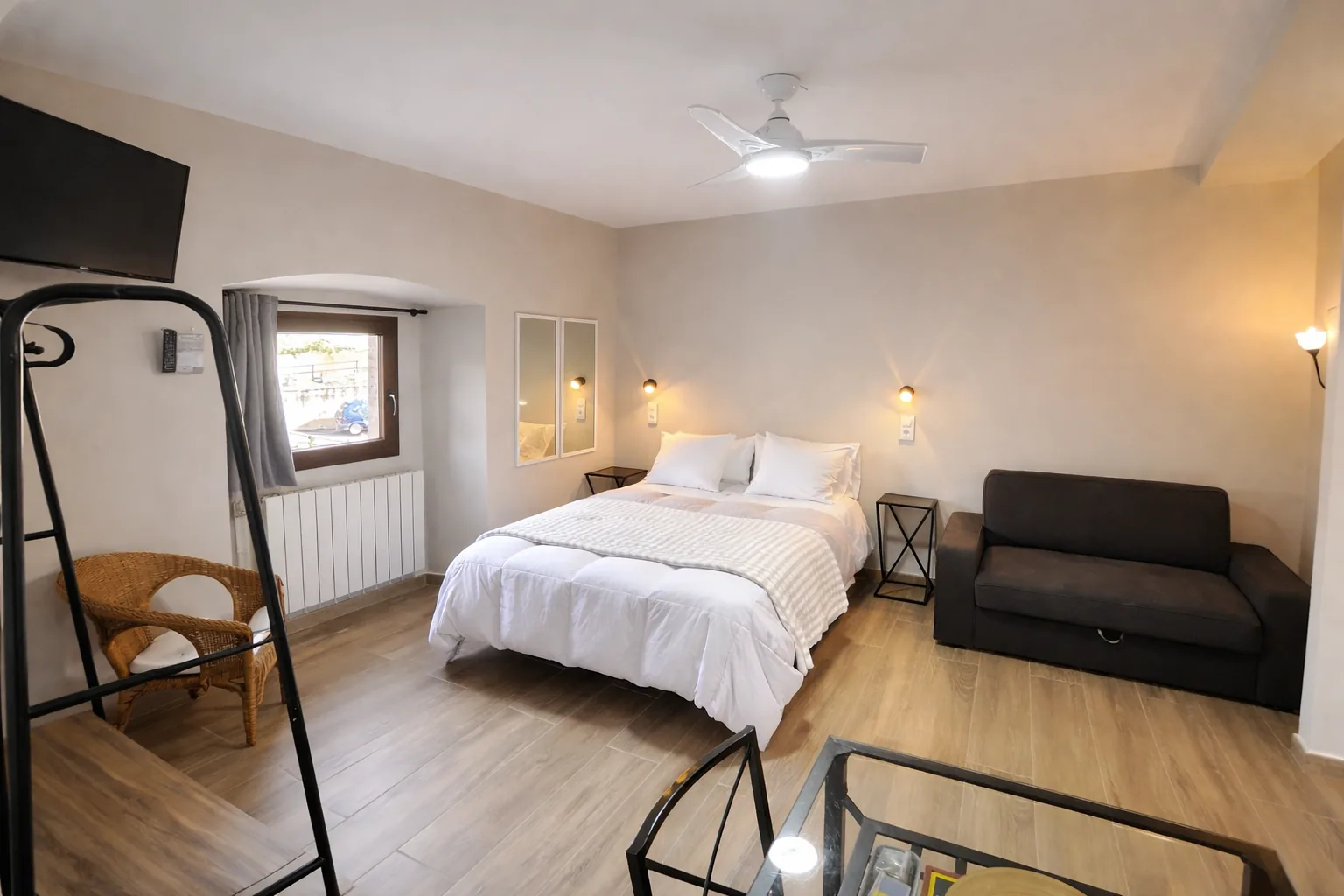 Dormitorio de Estudio 3 con cama doble, sofá y ventana.